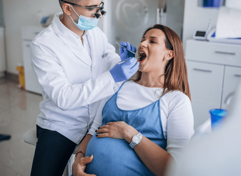 Pregnant woman receiving dental treatment.